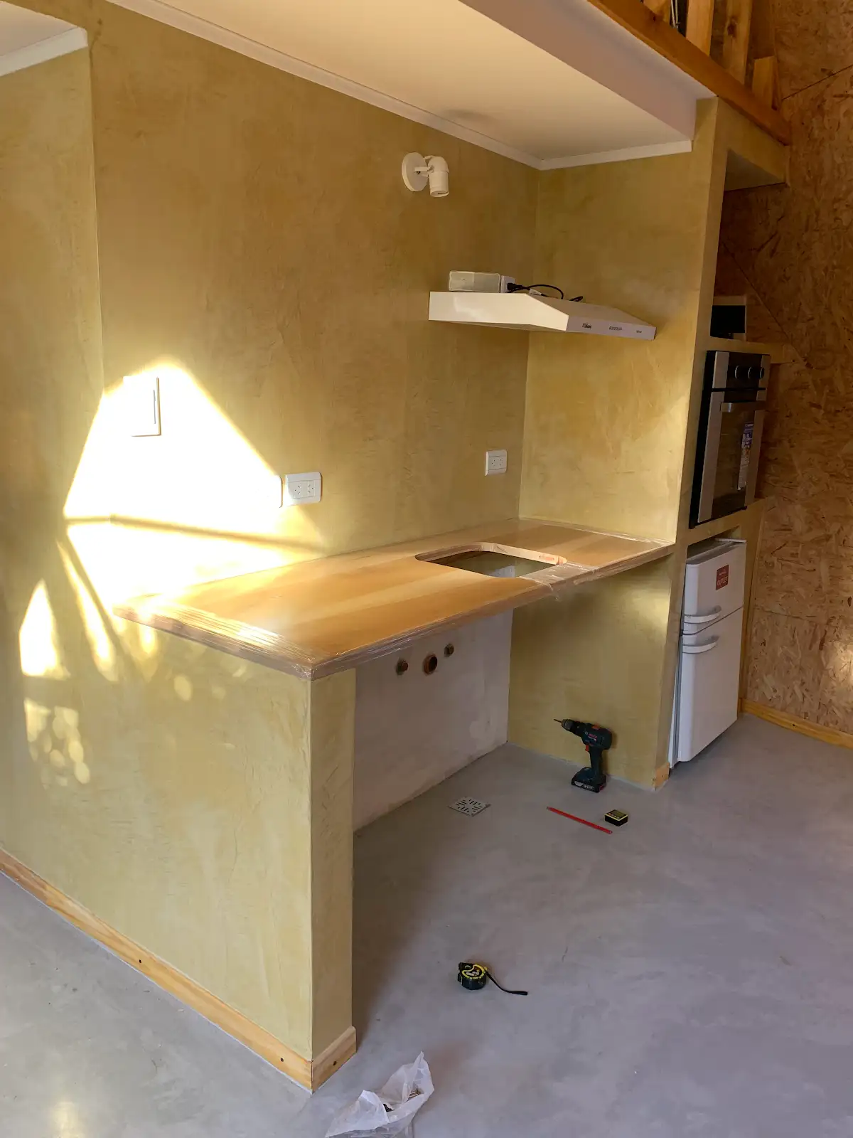 Cocina de Enzo durante las terminaciones, con mesada y horno empotrado.