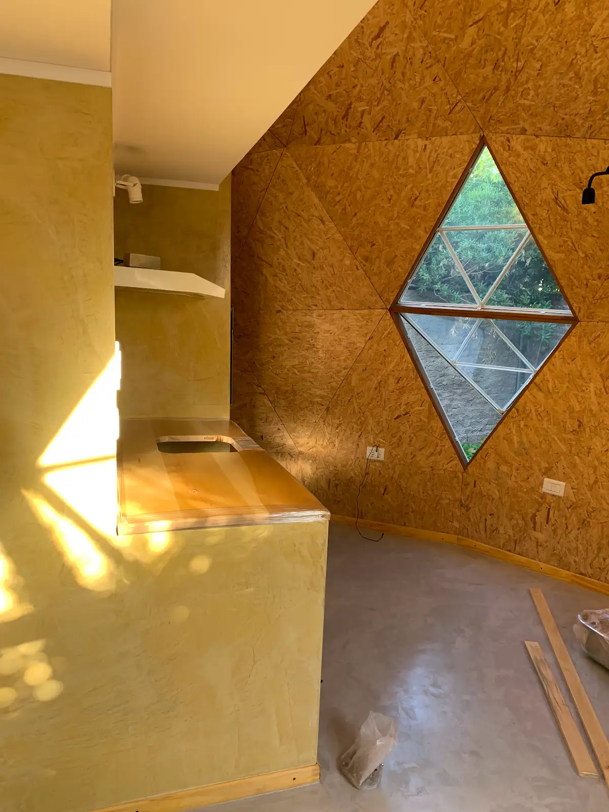 Interior de Enzo durante las terminaciones: cocina y ventana triangular doble.