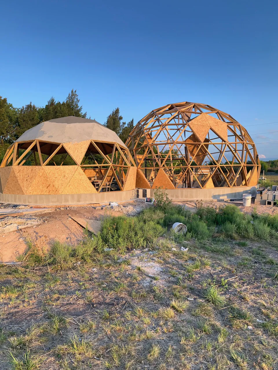 Dos domos de Caju con entramado de madera expuesto y algunos paneles de cubierta