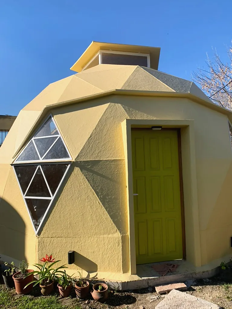 Enzo, domo amarillo con puerta verde y ventanas triangulares