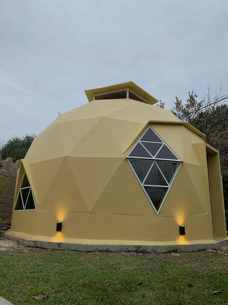 Enzo visto desde un costado, con ventana geométrica y luces junto a la base