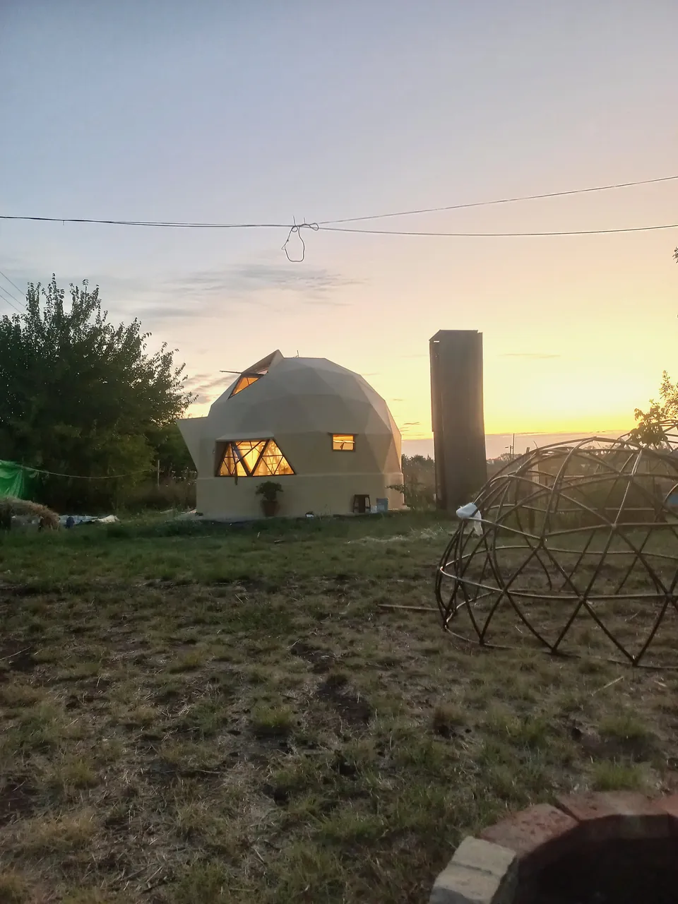 LunTao iluminado al fondo, con una estructura de varillas en primer plano